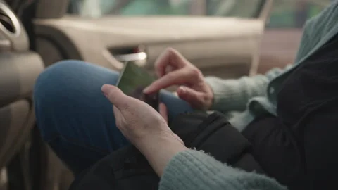 Passenger seated in a car types on a smartphone touchscreen, browsing maps .. Stock Footage 334796949