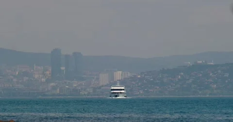 A passenger ship ferry sails into the sea against the backdrop of the city's Stock Footage 241234955