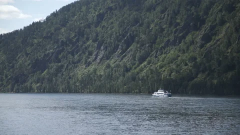 Passenger ship floating on blue river on background of mountains. Excursion ship Stock Footage 174129529