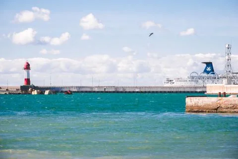 Passenger ship moored in harbor behind Olympic rings installation Stock Photos