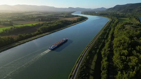 Passenger ship passing during sunrise in the Rhône riverbed in southern France Stock Footage 252762425