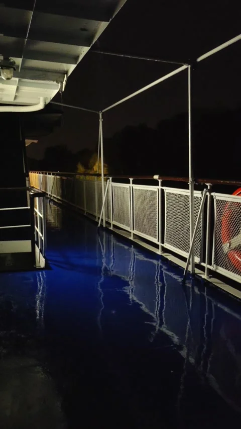 A passenger ship sails along a river at the night. A rainy summer evening. Stock Footage 280235236