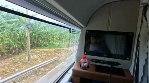 A passenger in sleeper bus with TV. Legs. Mountains view from a window Stock Footage 248679209