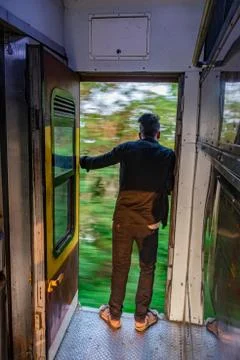 Passenger standing at running train gate in risk of life Stock Photos