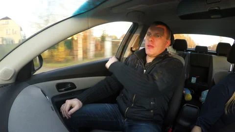 The passenger is strapping himself into the car, while it is driving Stock Footage 106736144