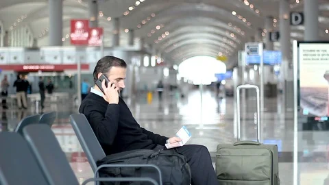 Passenger talking on the phone and checking information on boarding pass Stock Footage 99070304