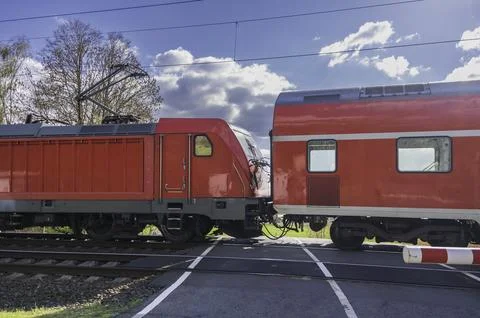 A passenger train approaching a level crossing. Stock Photos