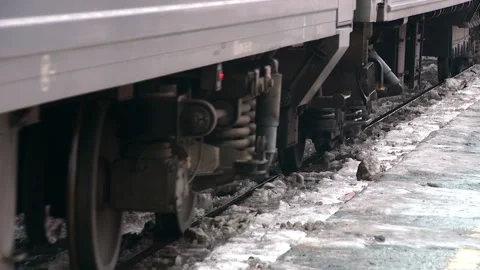 Passenger train arrives on the platform in the winter in the frame of wheels Stockbeeldmateriaal 124578434