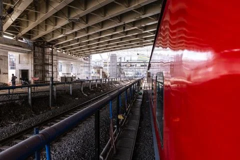 Passenger train beside under construction railway platform with tracks pers.. Foto stock