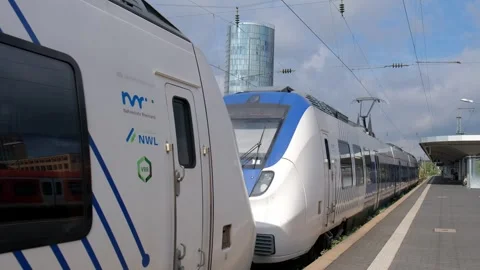 Passenger train at city station platform with modern skyscraper in background Stockbeeldmateriaal 337404923