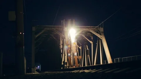 Passenger train crosses bridge at night Stock Footage 89393459
