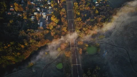 Passenger train crossing the bridge, autumn forest in fog Stock Footage 164506546
