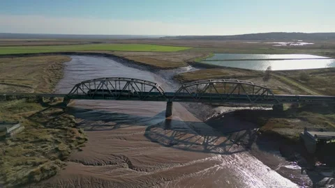Passenger Train Crossing Bridge over Scenic Countryside River Video stock 265118472