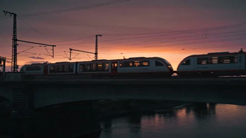 Passenger train crossing a bridge at sunset Stock Footage 315207872