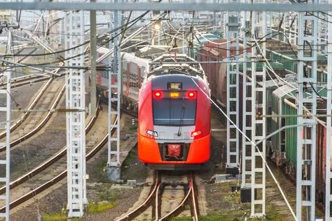 Passenger train leaving a large cargo station. Foto stock