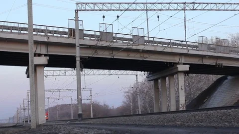 Passenger Train moving ahead on rails under the automobile bridge. Stock Footage 74541846