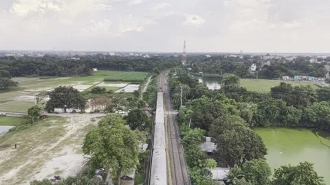 Passenger train moving forward on railway tracks through rural green landscape Stock Footage 344544386