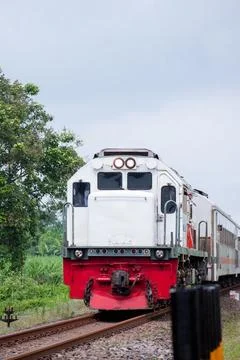 Passenger train moving forward on tracks in rural area Stock Photos