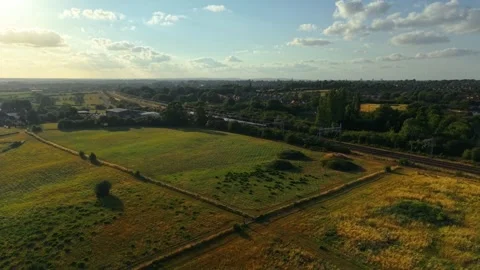 Passenger train moving through dry grassy fields near forest edge. Commuter Stock Footage 314106247