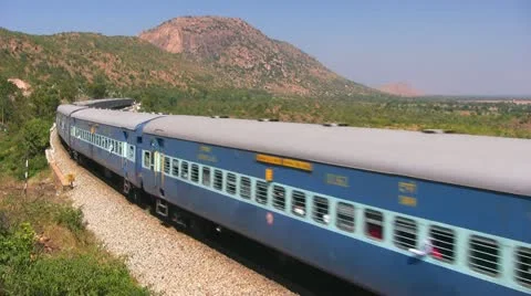 Passenger train passes by a mountainous terrain in India. Stock Footage 20535855