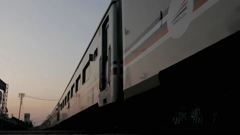 Passenger train passing by and leaving Yogyakarta station in the morning Stock Footage 130400530