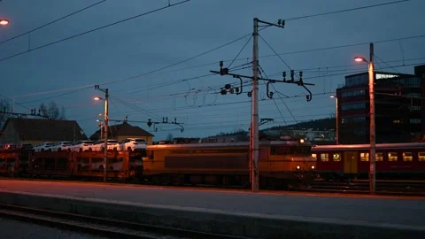 Passenger train passing by behind the double-decker car transporter Stock Footage 171105332