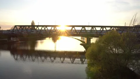 Passenger train passing a bridge  over Weser (Bremen) during sunset. 4k. Stock Footage 194544384