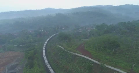 Passenger Train Passing by a Curved Rail Near Cikubang Bridge and Cipularang Stock Footage 131089883