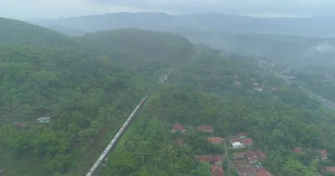 Passenger Train Passing by a Curved Rail Near Cikubang Bridge and Cipularang Stock Footage 131096572