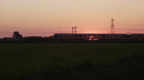 Passenger train passing by in front of setting sun 库存影片 42724446