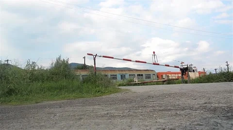 Passenger train passing on the left barrier because to wait until the cars pass Stock Footage 60798520