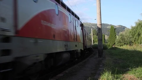 Passenger train passing by railway station in mountain resort in summer  Stock Footage 76838821