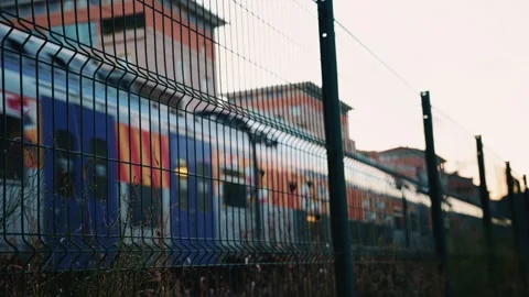 Passenger train passing through, framed by overhead electric cables and Stock Footage 325773949