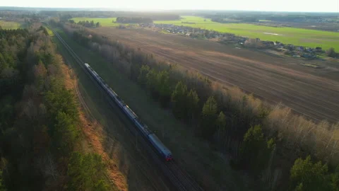 Passenger train on railway from forest, aerial view. Train with passenger cars Stock Footage 190069371