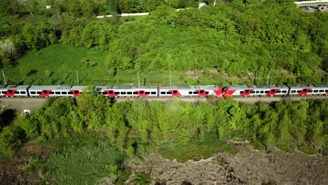 A passenger train rides along the forest on a sunny day. Russian Railways. Stock Footage 187697399
