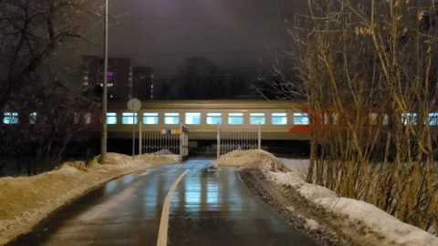 Passenger train rides on a winter night. Overhead Ped Crossing Video stock 170783985