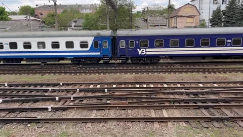 A passenger train slowly pulls up to a large large railway station Video stock 241654097