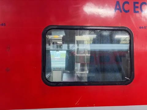 Passenger train window revealing empty coach compartment with new delhi sta.. Stock Photos