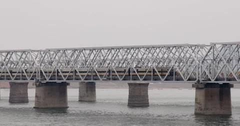 Passenger trains crossing a long truss bridge over Krishna river in India n.. Stock Footage 333601746