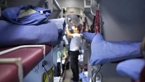 Passenger traveling in a modern sleeper train carriage, bunk beds prepared for Stock Footage 344697080