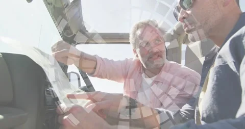 Passenger unfolding map, driver leaning, both tracing route for travel with Stock Footage 330355554