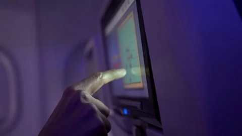 Passenger using in flight entertainment system on airplane Видео 323380748