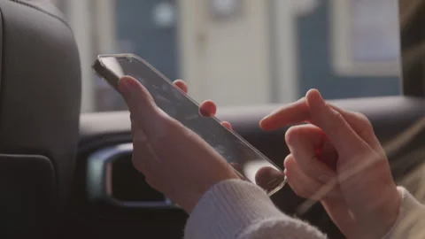Passenger Using Her Phone in the Backseat of a Car Stock Footage 208766869