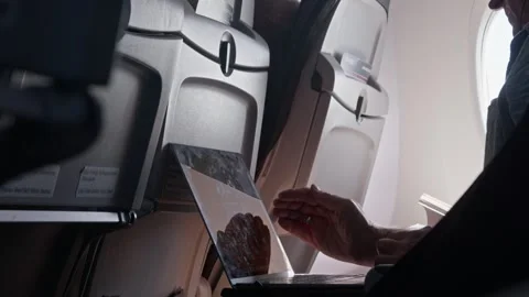 Passenger using laptop inside aircraft cabin medium shot Stock Footage 347880770