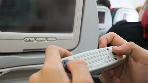 Passenger using remote control for airplane entertainment Stock-Footage 346355146