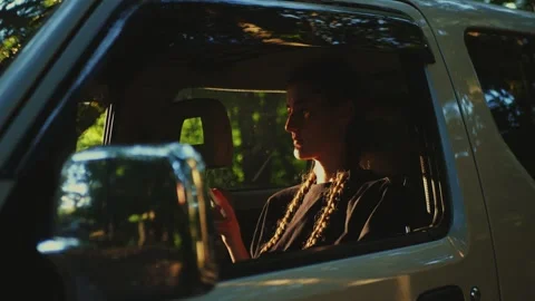Passenger using smartphone inside SUV near forest, representing connected... Stock Footage 341613072