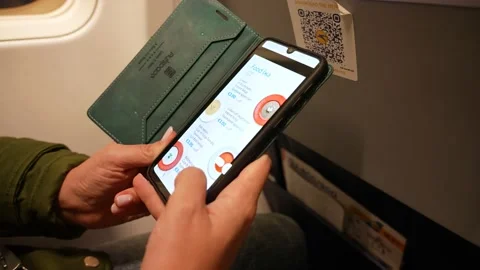 Passenger using smartphone to scan QR code on back of seat in plane Stock Footage 190653607
