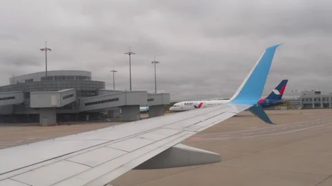 Passenger view of airplane wing and terminal at Vnukovo Airport Stock Footage 335543582