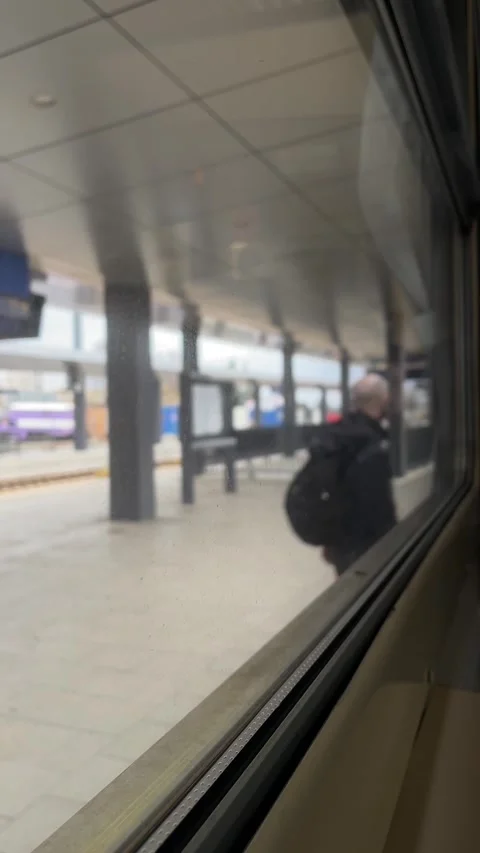 Passenger view featuring reflections and blurred station surroundings Stockbeeldmateriaal 347335010