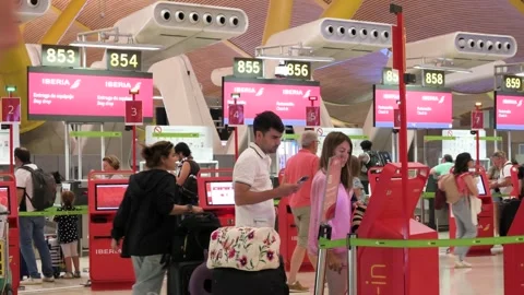 Passenger Walking Past Self Check-In Machines at Iberia Desks in Madrid-Barajas Stock Footage 305224649